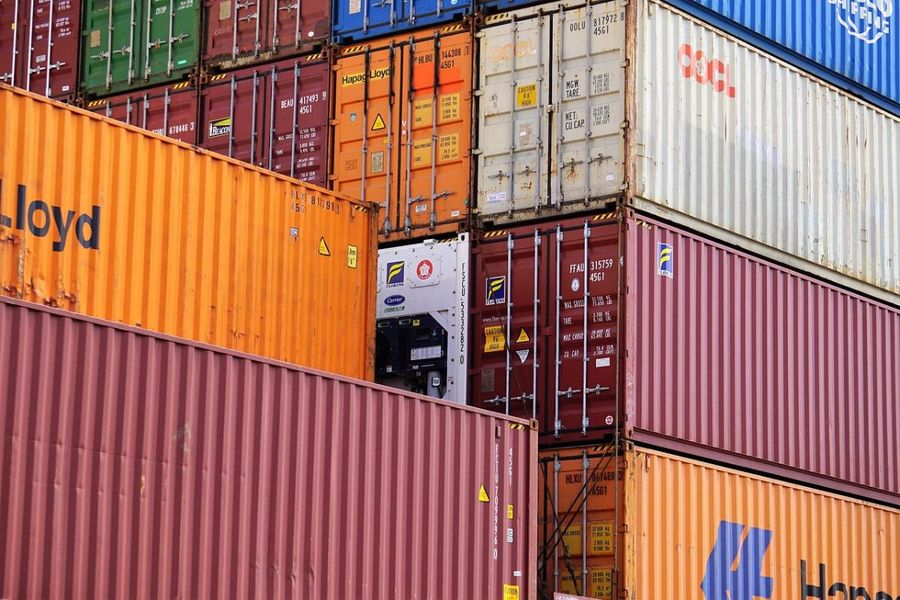 Rows of stacked multicolored shipping containers at a busy port
